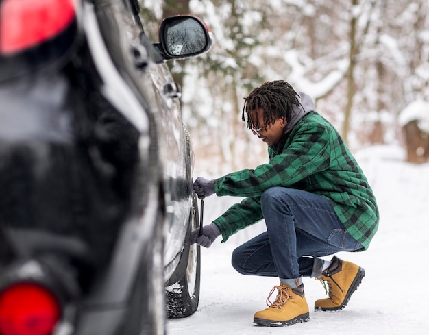 Uomo di vista laterale che controlla auto