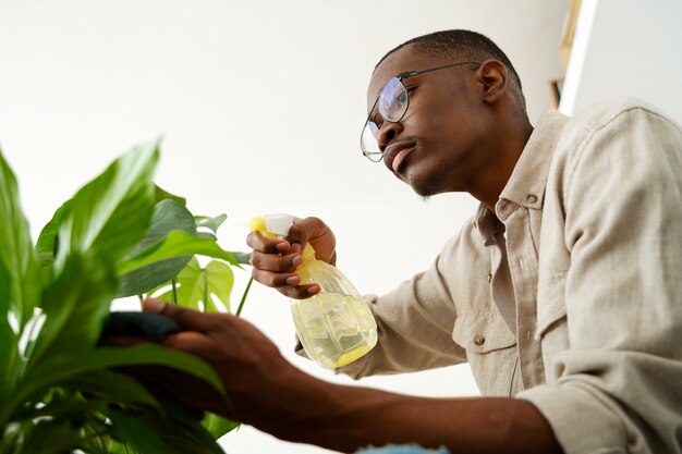 Side view man cleaning plant's leaf