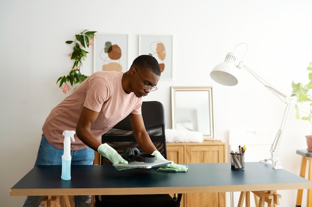 Free photo side view man cleaning table