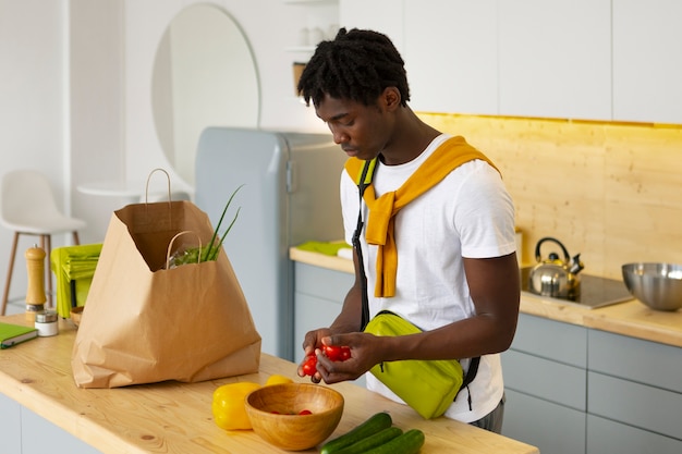 Free photo side view man cooking with smartphone