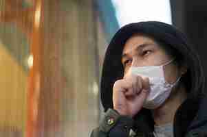 Free photo side view of man coughing while wearing a medical mask