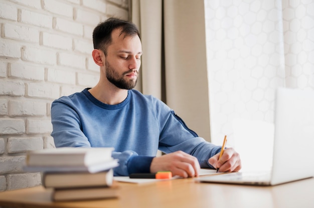 Side view of man at desk being online tutored