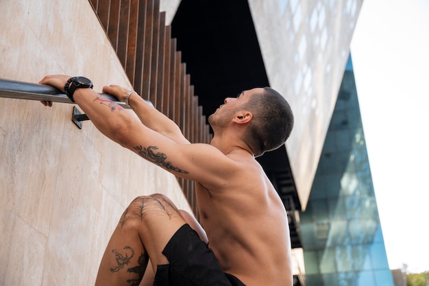 Foto gratuita uomo di vista laterale che fa addestramento di parkour