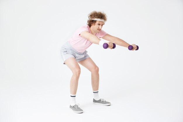 Side view of man doing squats, building muscles, training hard