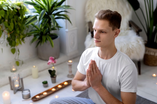 Side view man doing yoga indoors