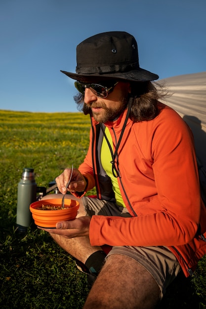 Foto gratuita uomo di vista laterale che mangia all'aperto