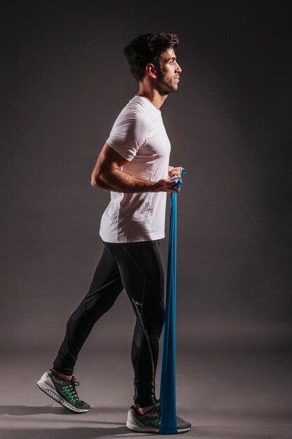 Side view man exercising with elastic band