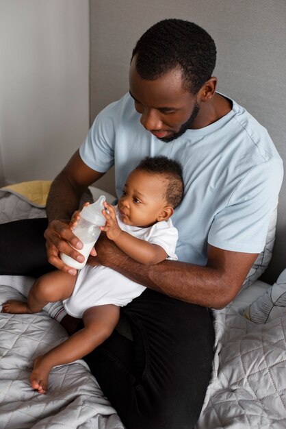 Side view man feeding baby