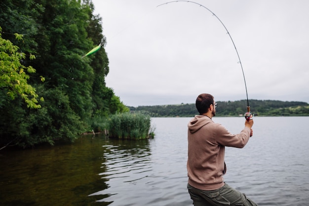 Foto gratuita vista laterale dell'uomo che pesca nel lago