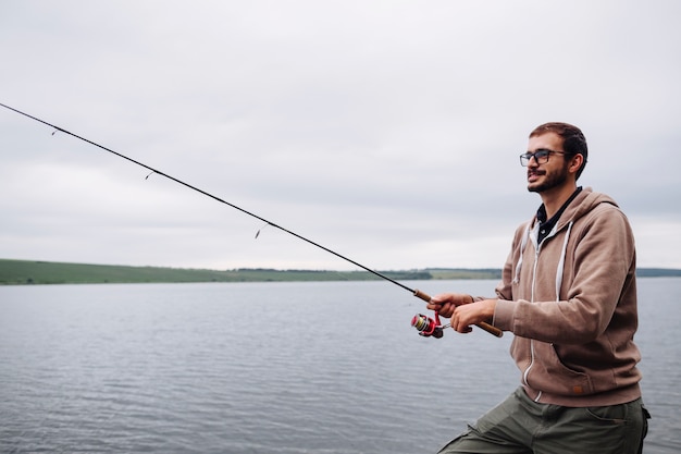 Side view of man fishing with rod on lake