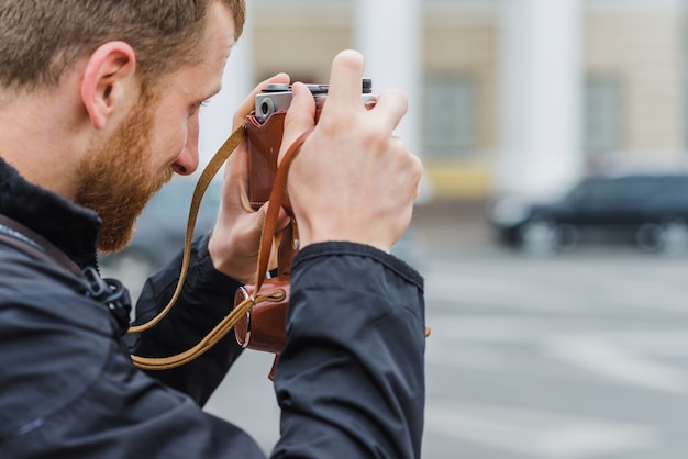 Side view of man focusing with camera