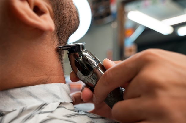 Free photo side view man getting groomed