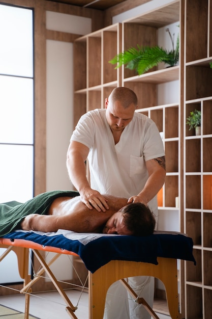 Side view man getting professional massage