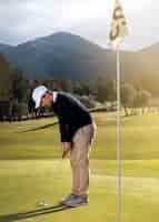 Foto gratuita vista laterale dell'uomo sul campo da golf con mazza e bandiera