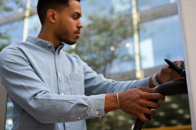 Side view man holding car charger