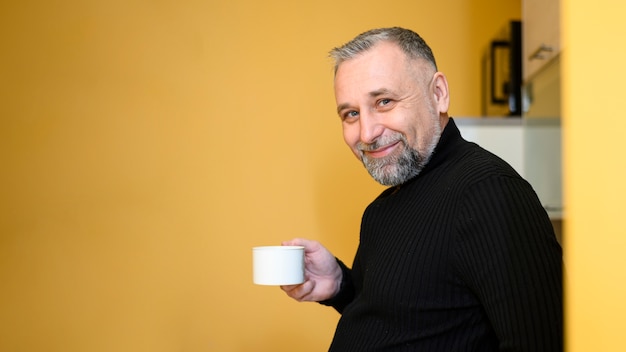 Side view man holding a cup of tea