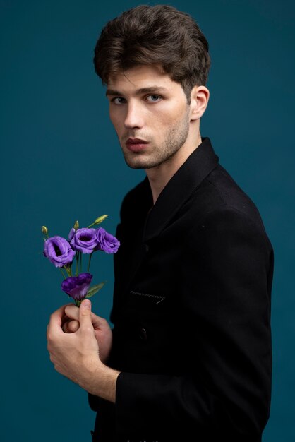 Side view man holding cute purple flower