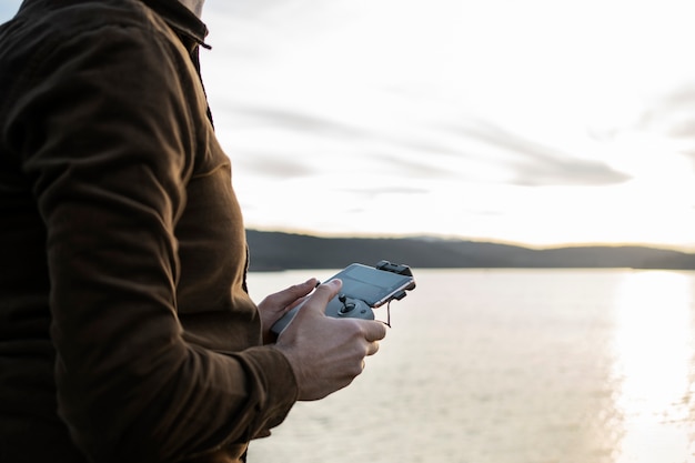 Side view man holding drone remote