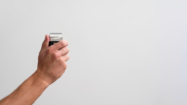 Side view of man holding electric shaver with copy space