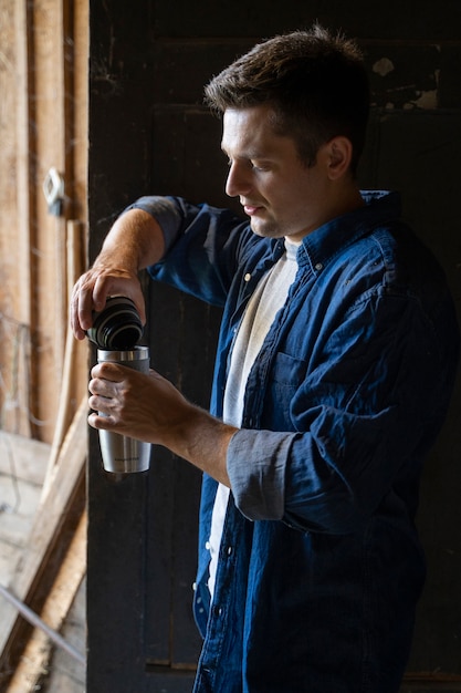 Side view man holding flask