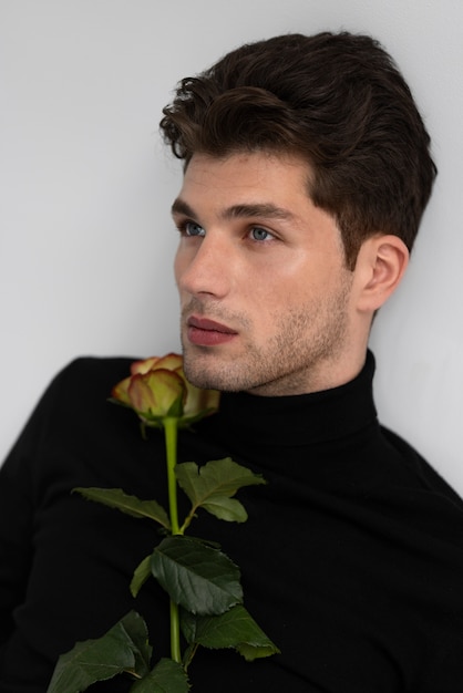 Free photo side view man holding flower