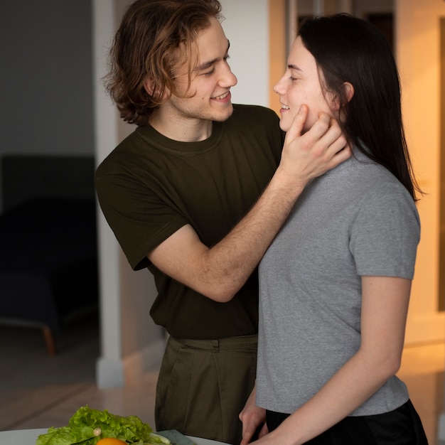 Free photo side view of man holding girlfriend while smiling