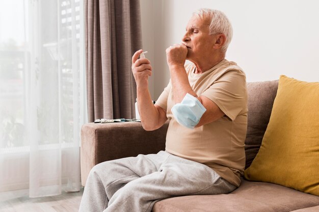 Side view man holding mask on elbow