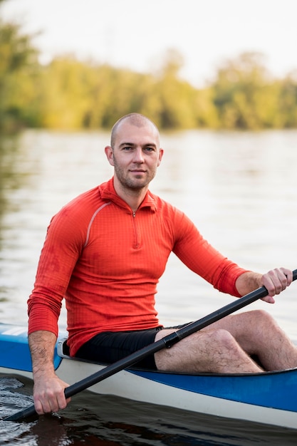 Free photo side view man holding oar