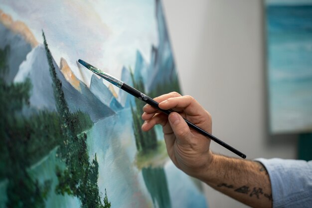 Side view man holding painting brush