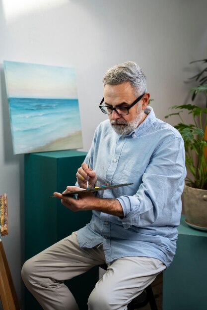 Side view man holding palette