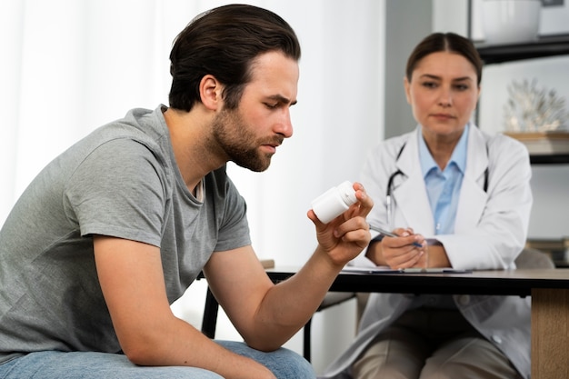 Free photo side view man holding pills container