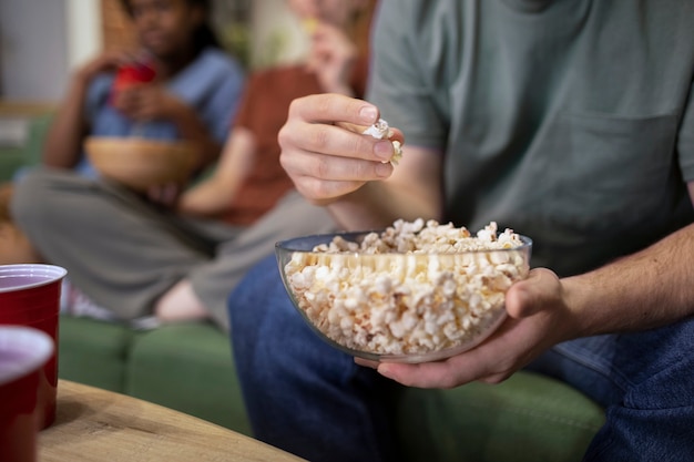 Free photo side view man holding popcorn bowl