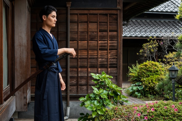 Side view man holding samurai sword