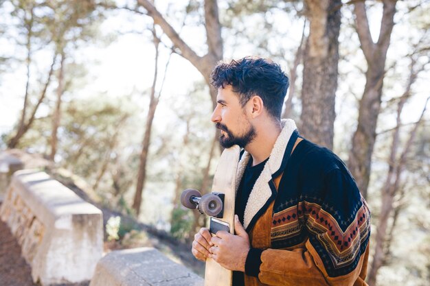 Side view of man holding skateboard