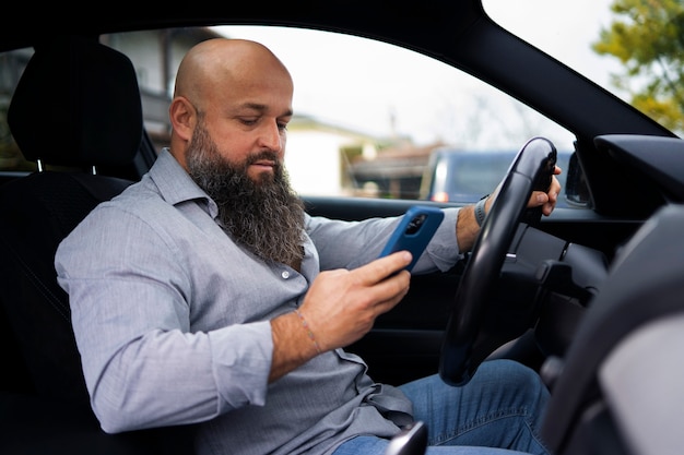 無料写真 車の中でスマートフォンを持っている側面図の男