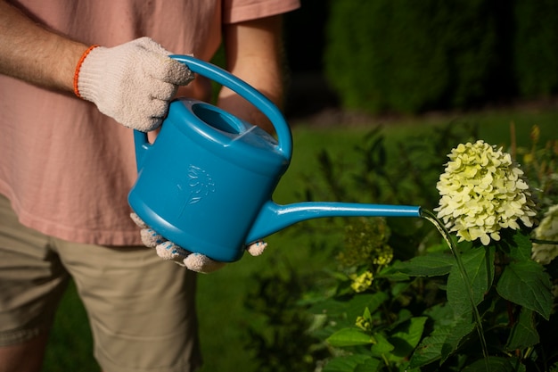 Side view man holding watering can