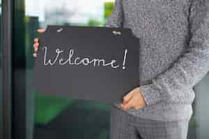 Free photo side view man holding welcome signs