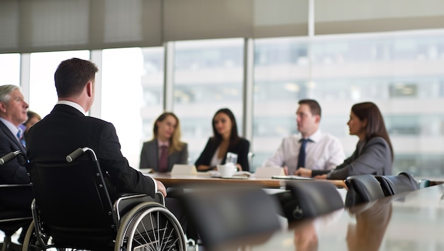 Бесплатное фото Сбочный вид мужчина в инвалидной коляске на работе