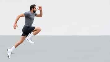 Бесплатное фото Вид сбоку мужчина прыгает на улице