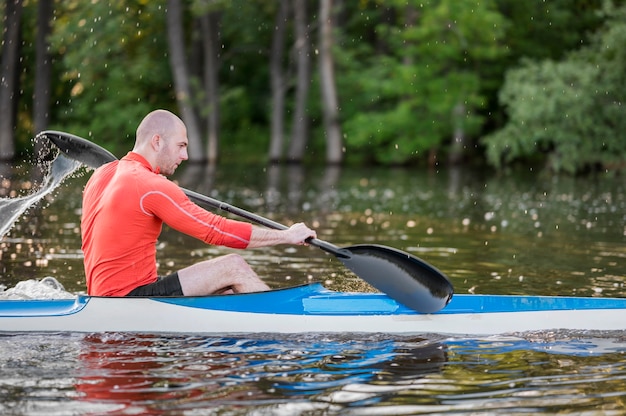 Foto gratuita vista laterale uomo in kayak con pagaia