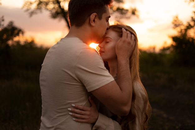 Side view man kissing woman on forehead