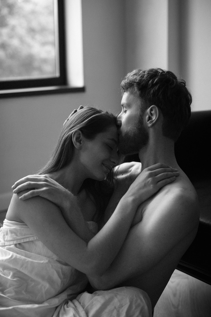 Free Photo side view man kissing woman on forehead