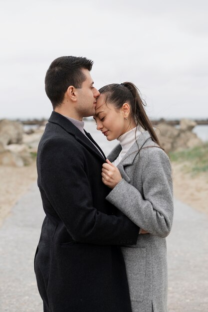 Side view man kissing woman on head