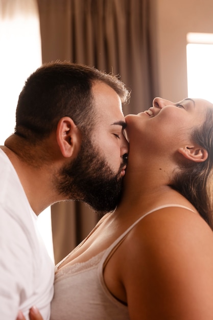 Вид сбоку мужчина целует женщину в шею