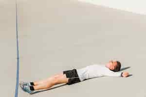 Free photo side view of man laying on the ground