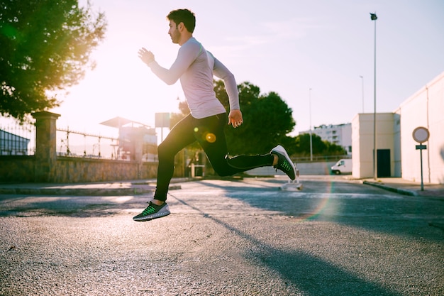 Side view man leaping on street