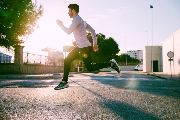 Side view man leaping on street