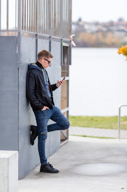 Side view man listening to music on earphones outside