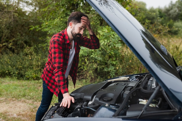 Side view of man looking at engine