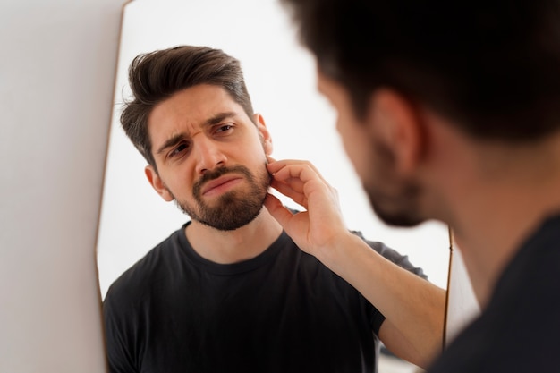 Side view man looking in the mirror